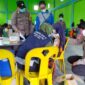 Kapolsek pengabuan dan personil bersama guru dampingi pelajar saat vaksinasi, di Kantor Desa Karya Maju, Kecamatan Pengabuan, Sabtu (15/1/22). FOTO : Polsek Pengabuan