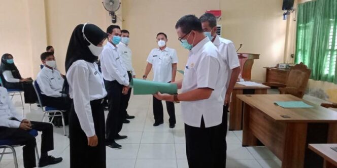 FOTO : Kepala BKPSDM Kabupaten Tanjung Jabung Barat, H. R. Gatot Suwarso, SH, MM Saat Menyerahkan SK kepada Salah Satu CPNS di Aula BKPSDM, Rabu (30/12/20).