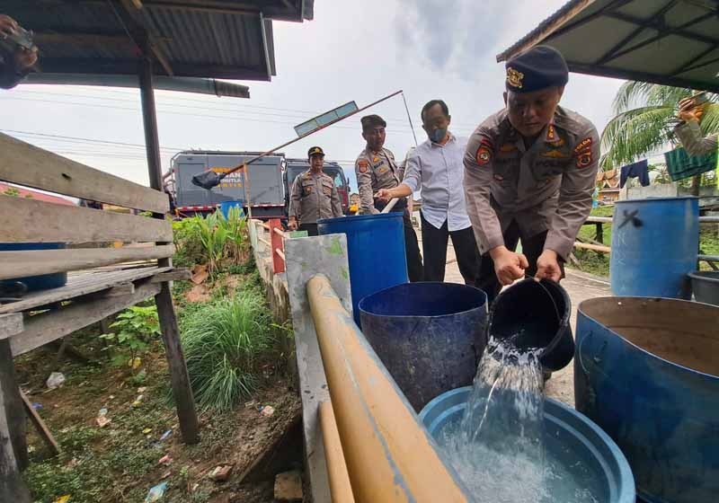 Wadir Samapta Polda Jambi AKBP Guntur Saputro Saat Melakaukan Distribusi Air Bersih. FOTO : Humas.