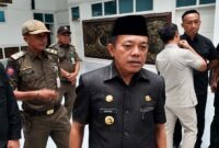 Gubernur Jambi, Al Haris, memberikan keterangan kepada awak media usai menghadiri sebuah agenda dinas. Tampak di latar belakang sejumlah petugas Satpol PP mendampingi jalannya kegiatan. (Foto: Dok. Istimewa/Tribunjambi)