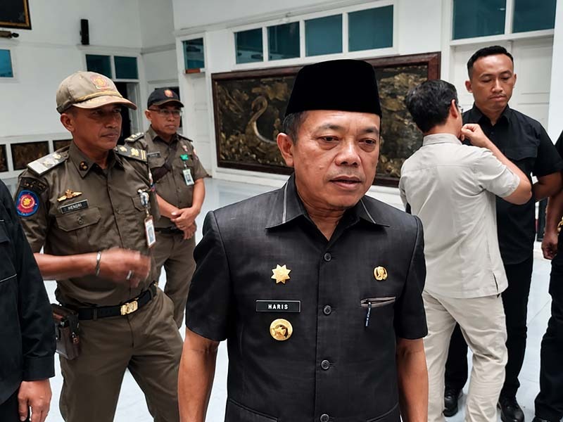 Gubernur Jambi, Al Haris, memberikan keterangan kepada awak media usai menghadiri sebuah agenda dinas. Tampak di latar belakang sejumlah petugas Satpol PP mendampingi jalannya kegiatan. (Foto: Dok. Istimewa/Tribunjambi)