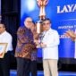 Menaker Yassierli menerima trofi Terbaik II Penilaian Kinerja Percepatan Pelaksanaan Berusaha 2026 dari Menteri Investasi Rosan Perkasa Roeslani di Jakarta, berkat komitmen penguatan regulasi ketenagakerjaan yang ramah investasi. (Foto: Dok. Kemnaker)