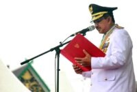 Bupati Drs. H. Anwar Sadat, M.Ag., selaku Inspektur Upacara saat membacakan teks Pancasila pada Upacara Peringatan HUT ke-81 Kemerdekaan Republik Indonesia di Alun-Alun Kuala Tungkal, Senin (17/08/2026). (FOTO : Dok. Prokopim)
