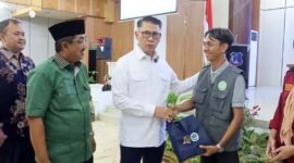 Bupati H. Anwar Sadat (kiri) bersama Anggota Komisi XII DPR RI Syarif Fasha (tengah) saat memberikan apresiasi kepada salah satu pegiat lingkungan dalam acara Sosialisasi Penanganan Sampah di Kantor Bupati, Selasa (28/7/2026). (FOTO : Dok. Prokopim TJB)