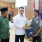 Bupati H. Anwar Sadat (kiri) bersama Anggota Komisi XII DPR RI Syarif Fasha (tengah) saat memberikan apresiasi kepada salah satu pegiat lingkungan dalam acara Sosialisasi Penanganan Sampah di Kantor Bupati, Selasa (28/7/2026). (FOTO : Dok. Prokopim TJB)