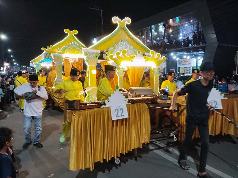 Potret kemewahan maket dalam Festival Arakan Sahur yang kini menjadi fokus utama penilaian. Dekorasi yang masif dan penggunaan lampu hias yang artistik seperti pada peserta nomor 22 ini mencerminkan tingginya biaya operasional yang harus dikeluarkan kelompok peserta, sebuah pergeseran dari tradisi tabuhan sederhana yang kini mulai terancam kelestariannya. FOTO : LINTASTUNGKAL