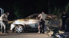 Polisi Memasang Garis Polisi pada Mobil Avanza yang Hangus Terbakar. FOTO : Polsek Kumpeh Ulu