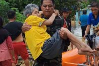 Aksi Babinsa Serma Rudi Tasgunarto Ketika Gendong Seorang Lansia yang Terdampak Banjir di Bungo. FOTO : Istimewa