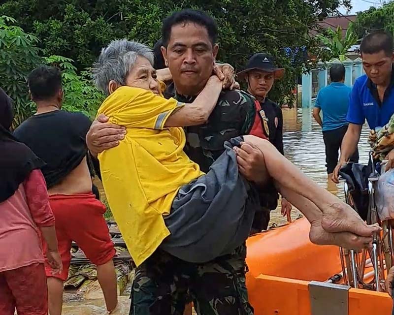 Aksi Babinsa Serma Rudi Tasgunarto Ketika Gendong Seorang Lansia yang Terdampak Banjir di Bungo. FOTO : Istimewa