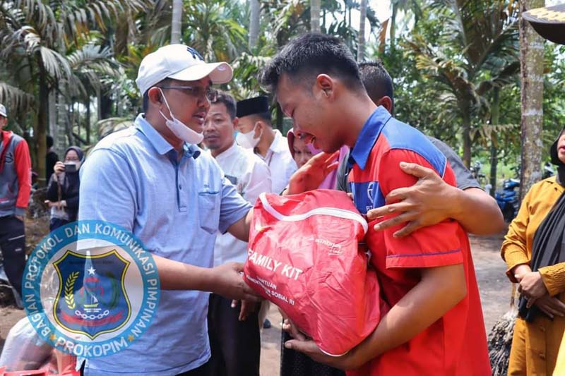 Bupati Tanjung Jabung Barat H Anwar Sadat menyerahkan bantuan kepada Korban kebakaran, Sabtu (14/5/2022). FOTO : PROKOPIM
