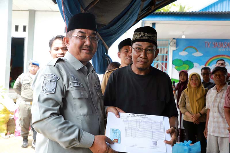 Bupati Tanjung Jabung Barat, Drs. H. Anwar Sadat, M.Ag., didampingi oleh Kepala Dinas Dukcapil, menyerahkan secara langsung bantuan dokumen kependudukan baru berupa Kartu Keluarga (KK) dan Kartu Tanda Penduduk (KTP) yang telah dicetak ulang kepada salah satu warga korban kebakaran di Kelurahan Teluk Nilau, Kecamatan Pengabuan. (FOTO : Dok. Prokopim TJB)