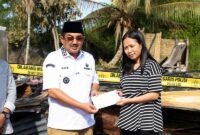Bupati H. Anwar Sadat, menyerahkan bantuan uang tunai (santunan) secara langsung kepada salah seorang warga korban musibah kebakaran di Kelurahan Sungai Nibung, Kecamatan Tungkal Ilir, Rabu (15/07). FOTO : Prokopim)