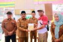 Bupati Tanjab Barat, Anwar Sadat (kedua kiri), didampingi Kadisdik H. Dahlan (kiri), Camat Pengabuan, Ismalil menyerahkan bantuan modal pascakebakaran senilai Rp29.350.000 kepada perwakilan warga di Teluk Nilau, Kecamatan Pengabuan, Senin (18/05). (FOTO : Dok. Prokopim Tanjab Barat)