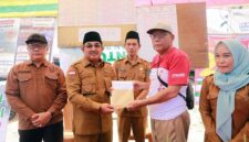 Bupati Tanjab Barat, Anwar Sadat (kedua kiri), didampingi Kadisdik H. Dahlan (kiri), Camat Pengabuan, Ismalil menyerahkan bantuan modal pascakebakaran senilai Rp29.350.000 kepada perwakilan warga di Teluk Nilau, Kecamatan Pengabuan, Senin (18/05). (FOTO : Dok. Prokopim Tanjab Barat)