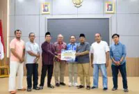Bupati H. Anwar Sadat, didampingi jajaran OPD saat menyerahkan bantuan penanganan musibah kebakaran dari PetroChina International Jabung Ltd sebesar Rp60.000.000,- untuk warga Kelurahan Teluk Nilau. Penyerahan yang berlangsung di Rumah Dinas Bupati pada Senin (13/07) (Foto: Humas Tanjab Barat)