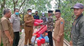 Kepala Dinas Sosial Didampingi Kalakhar BPBD dan Camat Pengabuan saat menyerahkan bantuan kepad Sabran, Senin (14/3/22). FOTO : Istimewa
