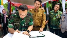 Dandim 0415/Jambi, Kolonel Inf Putra Negara, menandatangani berkas berita acara disaksikan Bupati Batang Hari, Mhd. Fadhil Arief (tengah), pada acara peresmian Jembatan Bailey yang menghubungkan Desa Pasar Terusan dan Desa Rantau Kapas Tuo di Kabupaten Batang Hari, Kamis (2/7/2026). (Foto: Dok. Pendim 0415/Jambi)