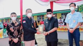 Ketua Paguyuban Sinar Mas Jambi H Hermawan Menyerahkan Bantuan Wakaf Mushaf Al-Quran kepada Bupati Tanjab Barat H. Anwar Sadat bersamaan Acara Bazar Minyak Goring di Tebing Tinggi, Selasa (26/4/22).