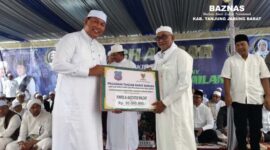 Wakil Bupati Tanjab Barat H. Hairan, SH Menyerahkan Bantuan BAZNAS Tanjab Barat Pengasuh Ponpes Al Baqiyatush Shalihat KH. Abdul Hakim. FOTO : Baznas TJB