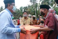 Bupati H. Anwar Sadat menyerahkan bantuan sosial Pemerintah Kabupaten Tanjab Barat kepada Siar Pani (70) yang mengalami musibah kebakaran di Parit Cegat, Selasa (11/05/21). FOTO : Prokopim.
