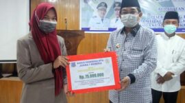 Bupati Tanjab Barat H. Anwar Sadat saat Menyerahkan Bonus Kepada Perwakilan Juara I Beregu Syarhil sebesar Rp75 Juta di ruang Pola Atas Kantor Bupati, Senin (21/12/21). FOTO : Prokopim