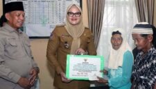 Momen Bupati Tanjab Timur, Hj. Dillah Hikmah Sari, S.T., secara simbolis menyerahkan bantuan produktif dan konsumtif dari Baznas Tanjab Timur kepada warga penerima manfaat (mustahik) bertempat di Kantor Camat Rantau Rasau. (FOTO : Dok. Diskominfo TJT)