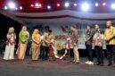 Bupati H. Anwar Sadat, memukul gong didampingi Ketua TP-PKK Hj. Fadhilah Sadat dan Wabup Dr. H. Katamso saat membuka Bulan Serengkuh Dayung Serentak Ketujuan 2026 di Alun-alun Kuala Tungkal, Sabtu (1/8). (Foto: Dok. Prokopim)