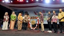 Bupati H. Anwar Sadat, memukul gong didampingi Ketua TP-PKK Hj. Fadhilah Sadat dan Wabup Dr. H. Katamso saat membuka Bulan Serengkuh Dayung Serentak Ketujuan 2026 di Alun-alun Kuala Tungkal, Sabtu (1/8). (Foto: Dok. Prokopim)