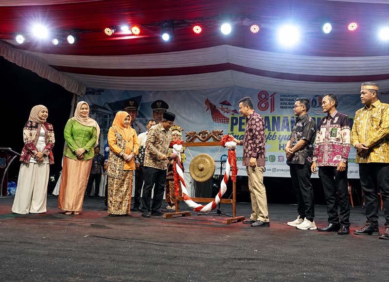 Bupati H. Anwar Sadat, memukul gong didampingi Ketua TP-PKK Hj. Fadhilah Sadat dan Wabup Dr. H. Katamso saat membuka Bulan Serengkuh Dayung Serentak Ketujuan 2026 di Alun-alun Kuala Tungkal, Sabtu (1/8). (Foto: Dok. Prokopim)