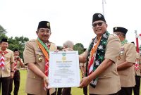 Bupati Tanjung Jabung Barat, H. Anwar Sadat Saat Menerima Piagam Penghargaan sebagai Tokoh Pramuka Perintis Utama dari Ketua Kwartir Nasional Gerakan Pramuka, Komjen Pol. (Purn.) Drs. Budi Waseso pada Apel Besar Peringatan Hari Pramuka ke-64 di Halaman Kantor Bupati Tanjung Jabung Timur, Rabu (19/11/25). FOTO : DOKPIM