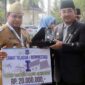 Bupati Tanjung Jabung Barat H Awar Sadat menyerahkan secara simbolis Uang pembinaan kepada Muhammad Ardiansyah. FOTO : Dok/Prokopim