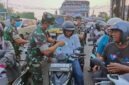 Danrem 042/Garuda Putih Brigjen TNI Nyamin, S.I.P., M.M dan personel TNI membagikan masker secara gratis kepada para pengendara sepeda motor dan masyarakat yang melintas di kawasan Simpang 5 Jelutung, Kota Jambi, Senin (24/8/2026). (Foto: Penrem 042/Gapu).