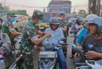 Danrem 042/Garuda Putih Brigjen TNI Nyamin, S.I.P., M.M dan personel TNI membagikan masker secara gratis kepada para pengendara sepeda motor dan masyarakat yang melintas di kawasan Simpang 5 Jelutung, Kota Jambi, Senin (24/8/2026). (Foto: Penrem 042/Gapu).