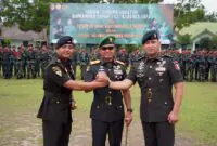 Danrem 042/Gapu Brigjen TNI Nyamin (tengah) menggenggam erat tangan Letkol Inf Dicky Sakti Maulana (kiri) dan Letkol Inf Aries Munandar Effendi (kanan) sebagai simbol estafet kepemimpinan Batalyon Infanteri 142/Ksatria Jaya yang resmi berganti, Rabu (8/7/2026). (Foto: Penrem 042/Gapu)