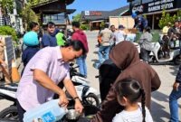 Petugas Pertamina Patra Niaga mengisikan Pertalite secara literan menggunakan jeriken langsung ke tangki motor warga di Denpasar, Bali, Jumat (16/10/2026). (FOTO : Dok. PERTAMINA)