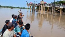 Sejumlah warga dan Tim SAR Gabungan menggunakan perahu kayu (pompong) saat menyusuri area sekitar runtuhnya jembatan dermaga Sungai Limau, Desa Sungai Landak, Kabupaten Tanjung Jabung Barat. Tampak di latar belakang material struktur jembatan penyeberangan yang ambruk ke dasar sungai, memicu dugaan kuat bahwa kedua korban pekerja pengelasan terjebak di bawah puing-puing bangunan tersebut. (FOTO: Dok. Istimewa/Lintastungkal)