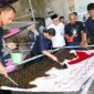 Para pekerja penyandang disabilitas di Rumah Batik Kinarsih, Blitar, saat menyelesaikan pembuatan kain batik di bawah tinjauan langsung Sekjen Kemnaker Cris Kuntadi. Kemnaker mengapresiasi pelaku usaha yang berani mematahkan stigma dengan membuka ruang kerja setara bagi ragam disabilitas. (Foto: Dok. Biro Humas Kemnaker) 