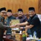 SINERGI EKSEKUTIF-LEGISLATIF: Bupati Tanjung Jabung Barat, Drs. H. Anwar Sadat, M.Ag. (kiri), menerima dokumen Pemandangan Umum Fraksi dari pimpinan DPRD dalam Rapat Paripurna LKPJ TA 2025 di Gedung DPRD Tanjab Barat, Senin (06/04). Sebanyak tujuh fraksi memberikan 
