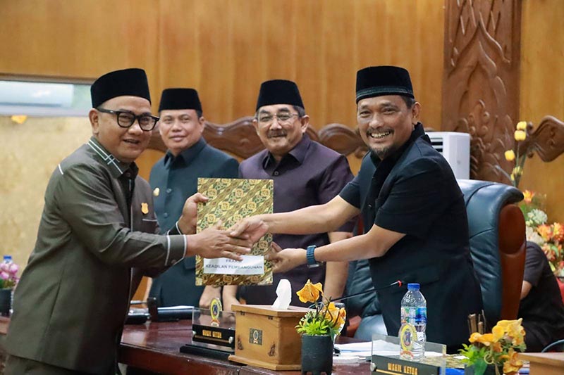 SINERGI EKSEKUTIF-LEGISLATIF: Bupati Tanjung Jabung Barat, Drs. H. Anwar Sadat, M.Ag. (kiri), menerima dokumen Pemandangan Umum Fraksi dari pimpinan DPRD dalam Rapat Paripurna LKPJ TA 2025 di Gedung DPRD Tanjab Barat, Senin (06/04). Sebanyak tujuh fraksi memberikan 