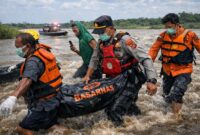 DRAMATIS: Detik-detik evakuasi jenazah Herminus (32) dari derasnya arus Sungai Batang Tebo oleh tim gabungan Polri dan Basarnas. Korban yang ditemukan warga pada pagi hari ini langsung dibawa ke RSUD H. Hanafie untuk proses identifikasi lebih lanjut. (FOTO : Dok. Istimwa)