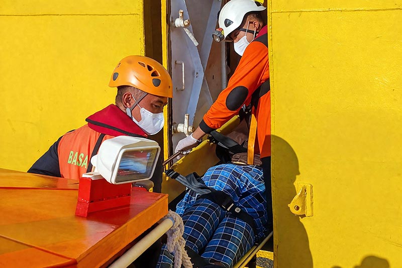 Sejumlah personel Basarnas melakukan evakuasi terhadap seorang penumpang kapal Roro rute Kuala Tungkal–Batam yang meninggal dunia di tengah pelayaran, Senin (06/04/2026). Korban yang sempat mengeluhkan sesak napas tersebut dievakuasi menggunakan tandu dari kapal penyeberangan menuju kapal penyelamat Basarnas untuk penanganan lebih lanjut di Batam. (Foto: Batampos)