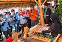 VP Community Involvement Development Pertamina Patra Niaga, Dian Hapsari Firasati (tengah, mengenakan rompi), berdialog dengan perajin saat meninjau proses pembuatan kain tradisional di Galeri Mina Tenun, Desa Sukarara, Kabupaten Lombok Tengah, Nusa Tenggara Barat (NTB). (FOTO : Dok. PERTAMINA)
