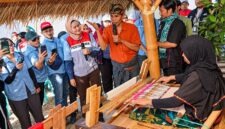 VP Community Involvement Development Pertamina Patra Niaga, Dian Hapsari Firasati (tengah, mengenakan rompi), berdialog dengan perajin saat meninjau proses pembuatan kain tradisional di Galeri Mina Tenun, Desa Sukarara, Kabupaten Lombok Tengah, Nusa Tenggara Barat (NTB). (FOTO : Dok. PERTAMINA)