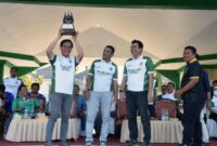 Ketua Asprov PSSI Jambi, Muhammad Fadhil Arief menyerahkan Piala Bergilir kepada Askab Batanghari Tandri Saputra diacara pembukaan Batanghari League 1 U-21 Tahun 2022. FOTO : Ist