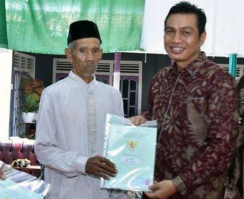 Bupati Batanghari Muhammad Fadhil Arief, SE membagikan secara simbolis sertifikat tanah program PTSL kepada warga Dusun Johor, RT 07 Desa Bungku, Kecamatan Bajubang, Kamis (9/6/22).