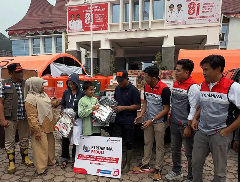 Bupati Solok, Jon Firman Pandu (tengah, topi hitam), didampingi perwakilan Pertamina Patra Niaga Regional Sumbagut, menyerahkan secara simbolis paket bantuan perlengkapan sekolah kepada perwakilan anak terdampak banjir bandang "Galodo" di Posko Batang Barus, Kabupaten Solok, Sumatera Barat, Oktober 2026. (FOTO : Dok. Pertamina)
