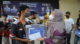 Bupati Muaro Jambi Hj. Masnah Busro Saat Menyerahkan hadiah Tropi kepada para juara Turnamen Game Mobile Legends Bupati Cup Milenial 2022, Minggu (15/05/22). FOTO : Noval