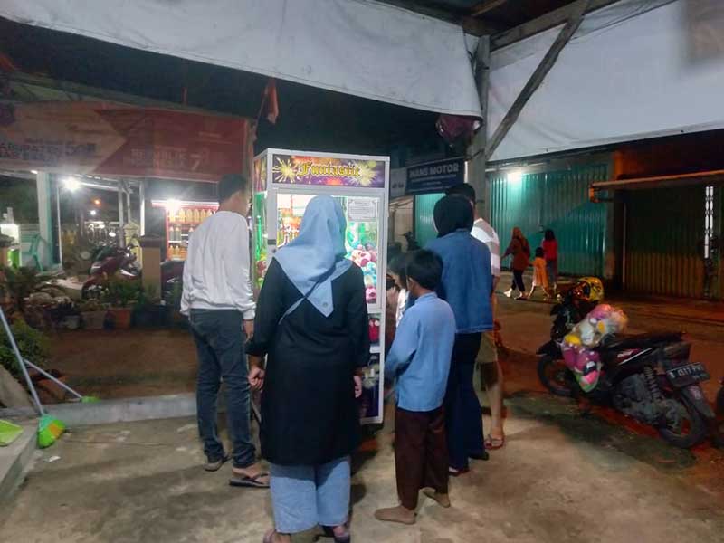 Anak-Anak dan orang Dewasa saat antri ingin memainkan Mesin Capit berhadiah Boneka di Jalan Kalimantan Tanjab Barat, Sabtu Malam (19/8/23). FOTO : LT