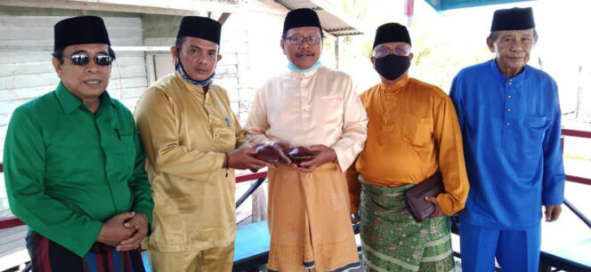 FOTO : Datuk Martunis M. Yusuf, M.Pd Mangku Sidi Palito saat menerima pemberian sepasang gasing dari Datuk Razakni yang merupakan sekretaris BM Adat Kecamatan Seberang Kota, Sabtu (14/11/20).