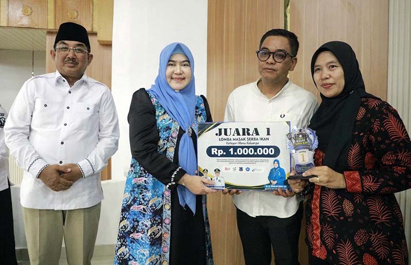 Bupati Tanjab Barat H. Anwar Sadat bersama Ketua TP-PKK Hj. Fadhilah Sadat Serahankan penghargaan kepada Juara I Lomba Masak Serba Ikan (GEMARIKAN) dengan hadiah uang tunai Rp1.000.000 dan trofi. (FOTO : Dok. Prokopim)
